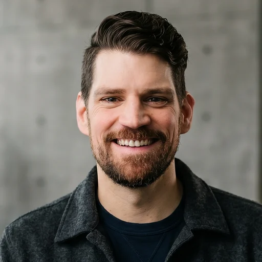 Dan Duyser, smiling, in front of a concrete wall.